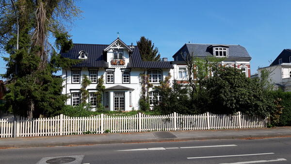 Eine weiße Sstadtvilla in der Barmstedter Moltkestraße. Der weiße Gartenzaun grenzt an den Gehweg.