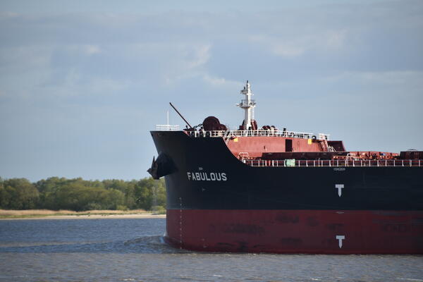 Ein großer Tanker fährt auf der Elbe bei Kollmar. Das Schiff trägt den Namen Fabulous, welcher in weißen Buchstaben auf dem dunklen Bug steht.