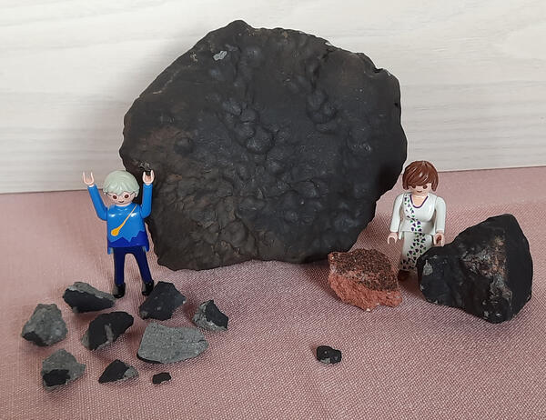 Die Elmshorner Meteoritenbruchstücke. Als Vergleich der Größe dienen zwei Spielfiguren.