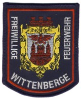 Feuerwehr-Abzeichen Wittenberge mit einem historischen Geb&auml;ude.
