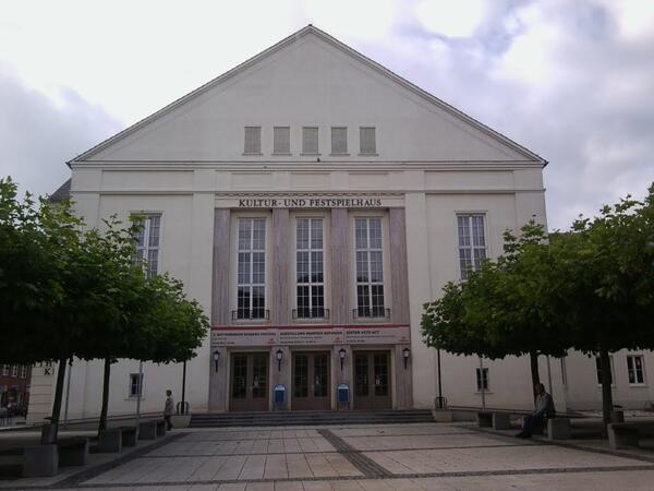 Bild vergr&ouml;&szlig;ern: Ein freier Platz mit kleiner Baumallee vor dem historischen Geb&auml;ude, dem Kululturhaus Wittenberge.