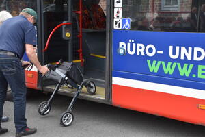 Bild vergr&ouml;&szlig;ern: Ein Busfahrer demonstriert, wie man mit einem Rollator in einen Bus einsteigt