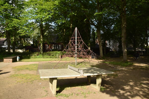 Eine Tischtennisplatte und ein Pyramiden-Klettererüst mit Seilen.