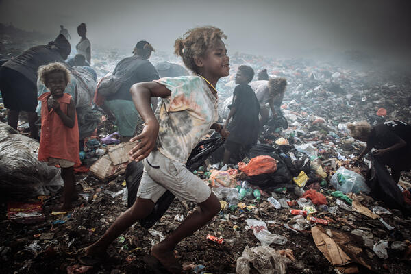 Kinder durchsuchen eine Müllhalde.