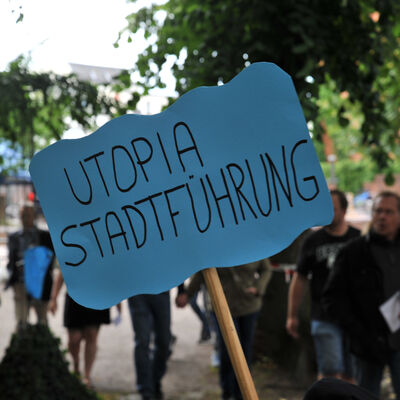Hinter einem Schild laufen die G&auml;ste der Kinderstadt.